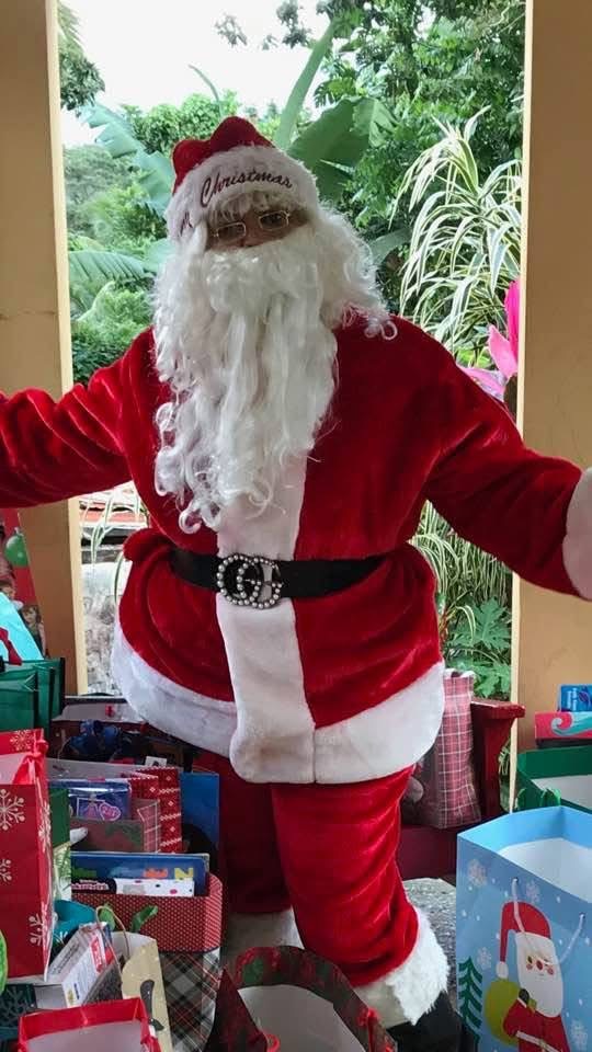 Santa with gift bags in a tropical setting
